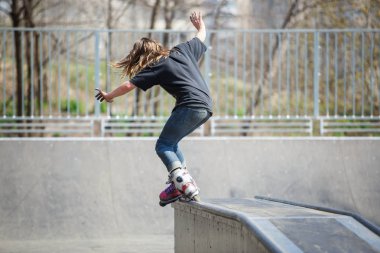Kiev - 15 Nisan, 2018: agresif satır içi skate Yarışması açık skatepark içinde. Genç kaykaycı çocuk demiryolu üzerinde rulman ağızları ile biler..