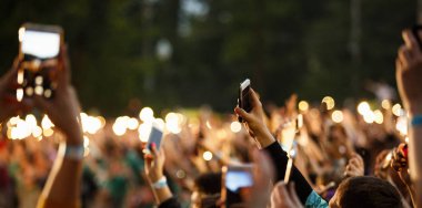 Moskova - 14 Jujy, 2017: El akıllı telefon ile konser film müzik hayranları büyük bir kalabalık. Müzik festival kalabalık açık hava eğlence olay akıllı telefonlar ile filme. Bokeh arka plan