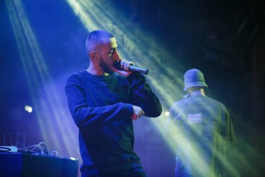 Moskova - 22 Şubat, 2017: popüler Rus rap düet grup Miyagi ve Endshpiel canlı gece kulübünde sahnede performans. Ünlü hip hop şarkıcı şarkı mikrofon sahnede. Konser sahne aydınlatma ayarı