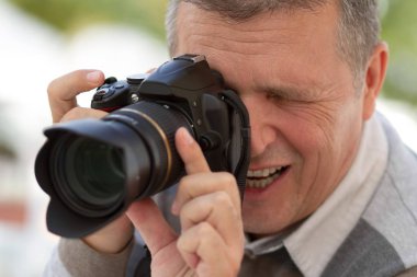 onların hafta parkta bir aydınlık yaz günde zevk mutlu bir aile. anne & oğul baba onun dslr fotoğraf makinesi ile fotoğraf alıyor iken eğleniyor