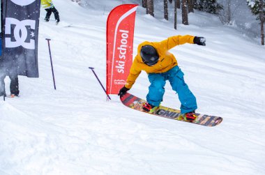 Bukovel, Ukrayna-19 Mart, 2018: Genç snowboard atlet rampa Kayak Park Bukovel kış kar tahtada yapmak hava hüner Park.Sportsman yarışmada doğa kış sporları sırasında atlar