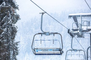 Bukovel, Ukrayna - 19 Mart, 2018: sandalye Asansör kayakçı ve Snowboard düşkünleri kış tatil için. Etkin turistler üzerinde snowboard binmek için Asansör ve kayaklar Bukovel Winter Park Karpat Dağları