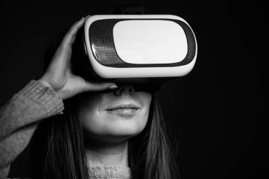Genç ve güzel kadın için mobil oyun uygulamalar yeni sanal gerçeklik gözlükle stüdyo portre. Kız mobil oyunlar apps ile yenilikçi 3d vr kulaklık kullanın. Trendy artar gerçeklik aygıtı kullanımda