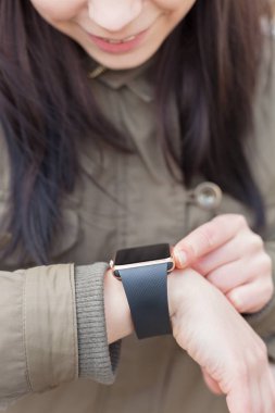 Yeni iletide onun modern akıllı kol saati okuma gülümseyen genç kız. Bu kişi her zaman sosyal medya ve internet bağlı. 