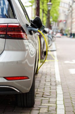 Yeni yenilikçi hibrid elektrikli araba chraging pillerle güç kablosunu şehrin sokak. Moden kentsel ulaşım Hava kirliliği sağlar. Çevre bakım ve güç koruma kavramı