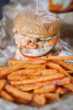 Büyük şişman hamburger sosu ve kızarmış havuç dilimleri ile fast food restoranda. Kalori ve yüksek düzey kolesterol ile Burger Cafe menü. Eatind abur cubur durabiliriz..... bir diyet