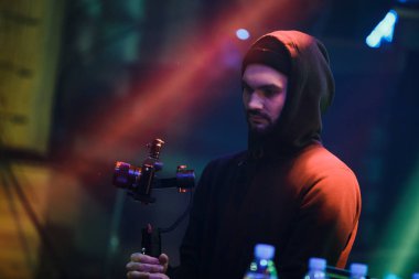 Moskova-16 Şubat 2017: taşınabilir sabit cam ve küçük modern DSLR fotoğraf makinesi ile sahnede genç video kamera adam film konseri. Gece kulübü eğlence gösterisi filme