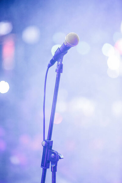 MOSCOW - 30 NOVEMBER, 2016: Vocal microphone on stand on scene at party in night club.Nightclub music show,mic for singer in bright stage light.Concert lighting