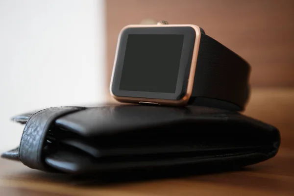 Stylish smart watches on black leather wallet.Business style gadget to stay always connected.Put mobile app logo or text on empty screen.Cool new device for wireless networks