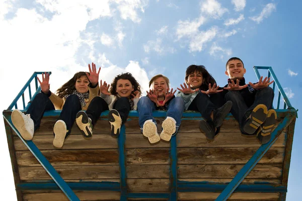 Five Teenage Friends Sitting Together Legs Hanging Throwing Hands You — Stock Photo, Image