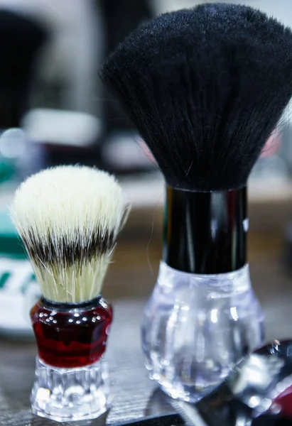 Professional barber shaving brushes for foam in barbershop. Specialized high quality swab brush for shaving cream. Male beauty treatment in barber shop salon.
