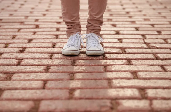 穿着白色运动鞋的女孩站在砖路上 太阳背光 时尚口香糖鞋 青年时尚象征 — 图库照片