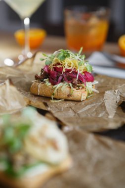 Baharat yaprakları ile lezzetli Italyan Bruschetta Antipasti çanak, yengeç topuz ekmek & salata kağıt plaka üzerinde servis Akdeniz restoran. Gurme Canape çanak dikey çekim. Tadı ile yiyin