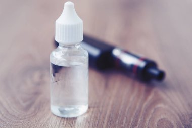 E-suyu için e-çiğ ve vaping aygıt. Buharlaştırıcı ve lezzetli dolum e-sıvı. Sıvı tütün probilen glicol ve gliserin temel ile tekrar doldur. Metin üzerinde şeffaf şişe yerleştirin.