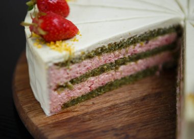 Taze restoranda lezzetli İtalyan tatlı yemek kesti. Pisstacchio bisküvi hamur kremalı pasta. Çilek dekorasyon ve tadı için. Güzel tatlı yiyecek yemek listesi içinde restoran ile pasta