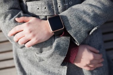 Modern akıllı kol saati takan bankta oturan kız. Bu kişi her zaman sosyal medya ve internet parkta oturan hatta bağlı. 