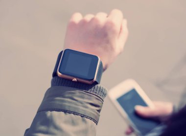 Kız onu gadget iletide kontrol. Bir el ve diğer elinde akıllı telefon akıllı varken. Modern teknoloji ve eski film tonlama.