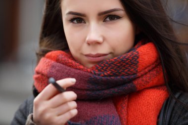 Güzel ve hüzünlü genç esmer kız vaping ecig sopa sigara kalem. Modern cihaz nikotin sigara Sigara kötü alışkanlığı çıkmak vaper kız için. Sağlıksız kadın yaşam tarzı. Sigara Tütün sigara durdurmak