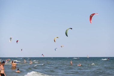 Odessa-25 Ağustos, 2017: Kitesurfing Karadeniz üzerinde. Genç ve aktif sporcular için eğlenceli su sporları. İnsanlar iyi yaz günde uçurtma sörf tahtası üzerinde dalgalar binmek