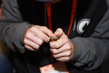 Kiev, Ukrayna-14 Nisan, 2018: Titanyum tel ve Vape Expo dükkanda vaping cihazı ile gliserin sıvı sigara için fitil değiştirme uzmanı. Profesyonel tamir elektronik sigara Gadget'ta teller