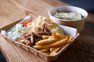 Kağıt tabak tablo büyük geleneksel Yunan mutfağı yemek hazır. Fast food medditeranean restoran menü yemekleri. Kavrulmuş et souvlaki yemeğin tadını çıkarın ve kızarmış gyros rulo. Abur cubur yemek listesi