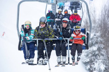 Bukovel, Ukrayna - 19 Mart, 2018: sandalye Asansör kayakçı ve Snowboard düşkünleri kış tatil için. Etkin turistler üzerinde snowboard binmek için Asansör ve kayaklar Bukovel Winter Park Karpat Dağları