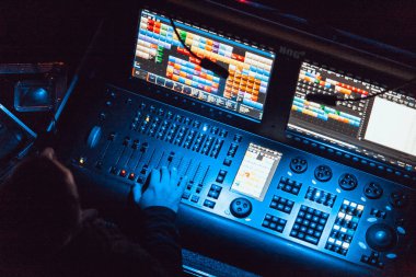 Moskova - 20 Ekim, 2016: profesyonel konser ses ve sahne aydınlatma teknisyeni iş başında. DMX sahne ışık kontrol paneli. Fader ve topuzlar kontrol renk ve birim