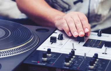 Profesyonel ses denetleyicisi ve pikap vinil plak çalar müzik karıştırma Dj el. Elleri, kolları ve düzenleyiciler üzerinde odaklanmak. 