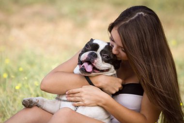 genç esmer kız parkta onun sağlıklı genç bulldog ile oynarken