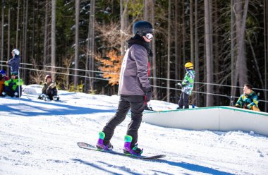 Bukovel, Ukrayna-19 Mart, 2018: Bukovel kar Park resort özel Kayak yolda gemide Snowboarder atlet sürmek. Güney Avrupa'da aşırı kış sporları. Tatil için seyahat hedef
