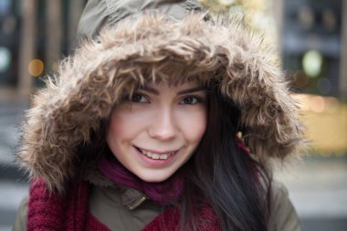 Noel ağacı açık havada genç esmer kız poz, açık renklerle dekore edilmiş