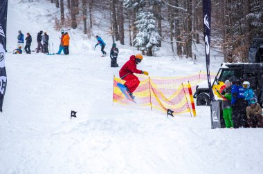 Bukovel, Ukrayna-19 Mart, 2018: Genç snowboard atlet rampa Kayak Park Bukovel kış kar tahtada yapmak hava hüner Park.Sportsman yarışmada doğa kış sporları sırasında atlar