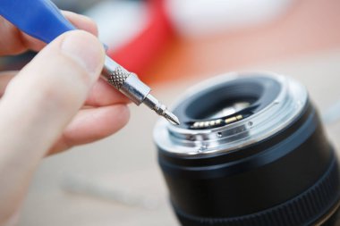 Sökme ve onarım işlemi profesyonel modern dijital tek reflex fotoğraf makinesi lens. Kamera mercekleri araçlarıyla tamir servis merkezi uzmanı. Dissassembled kırık dijital SLR lens 