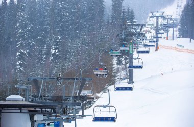 Bukovel, Ukrayna - 19 Mart, 2018: sandalye Asansör kayakçı ve Snowboard düşkünleri kış tatil için. Etkin turistler üzerinde snowboard binmek için Asansör ve kayaklar Bukovel Winter Park Karpat Dağları