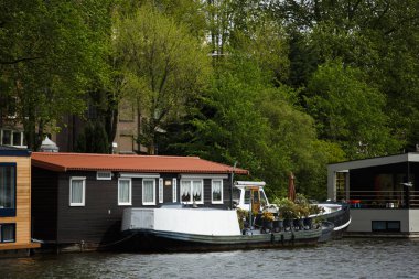 Amsterdam,Hollanda-27 Nisan,2019: Amsterdam eski şehir bölgesinin merkezinde Amstel Nehri Kanalı. Merkezinde köprü ile geniş nehir bankaları, kıyıda eski Hollanda evleri