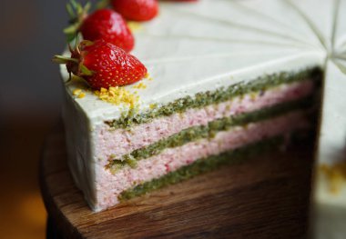 Taze restoranda lezzetli İtalyan tatlı yemek kesti. Pisstacchio bisküvi hamur kremalı pasta. Çilek dekorasyon ve tadı için. Güzel tatlı yiyecek yemek listesi içinde restoran ile pasta