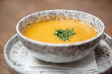 Geleneksel Gürcü turuncu Mısır çorbası gri mermer çanak içinde masaya servis. Lüks iş öğle yemeği menüsü egzotik kafede. Yakın çekim, çorba ve baharat meze üzerinde odak