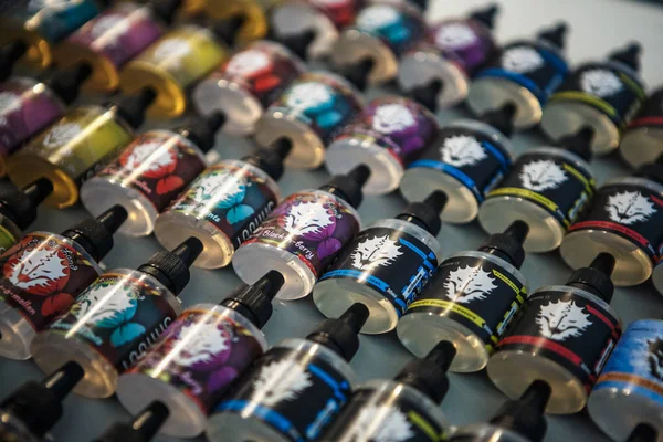 Kiev, Ukrayna-14 Nisan, 2018: yeni lezzetli vape suyu sigara elektronik vaping cihazlar ile için. Sigara içenler vape Expo Satılık. Plastik şişe kapları ile ejuice gliserin sıvı vaper mağaza