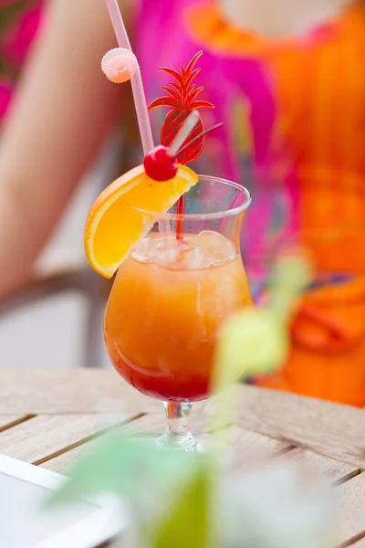 Beautiful young lady enjoying her fresh cocktail sitting in a restaurant outdoors