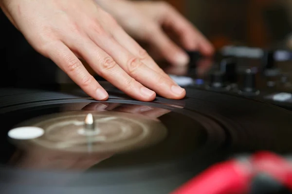 Djs hand scratch vinyl record on turn table.Professional night club turntables record player in focus.Party dj audio equipment setup.Play tracks,scratch records at night adult entertainment event
