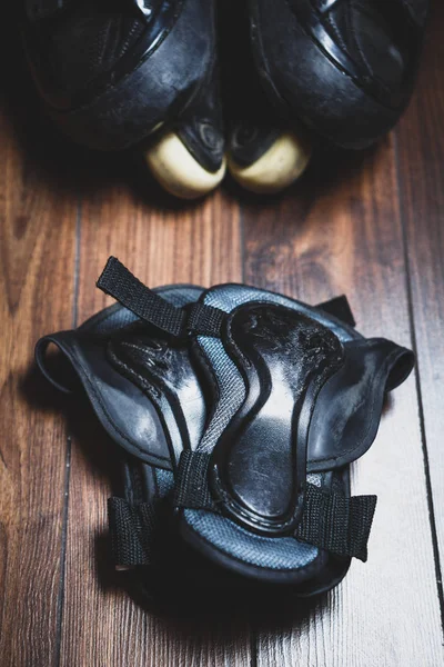 Protective wrist guard gloves and big black aggressive inline roller blades.Scratched wrist protection shields protect your palm from scratches,wounds and broken bones while skating on skates