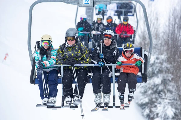 Bukovel, Ukrayna - 19 Mart, 2018: sandalye Asansör kayakçı ve Snowboard düşkünleri kış tatil için. Etkin turistler üzerinde snowboard binmek için Asansör ve kayaklar Bukovel Winter Park Karpat Dağları