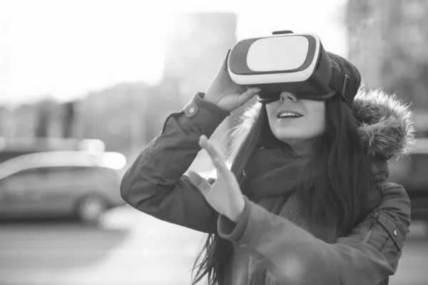 Young girl enjoy playing with cool new virtual reality glasses for mobile gaming applications.Use mobile apps with innovative virtual technology.Augmented reality gamer gadget.Woman play on vr headset