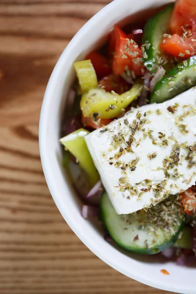 Tasty & healthy low fat Greek salad.Feta chesse,olives & vegetables served in olive oil with spices.Good dieting with fesh natural ingredients.Eat healthy fast food.Over head macro shot