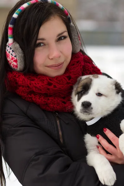 雪の中で面白いパグ子犬と遊ぶ若い Giel — ストック写真