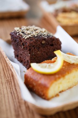 Taze pişmiş hamur işi fast food restoran ucuz kağıt tabaklarda servis. Kafede tatlı tatlı yemek keyfini çıkarın. Ekmek yapım ürünleri - brownie kek ve limon tart