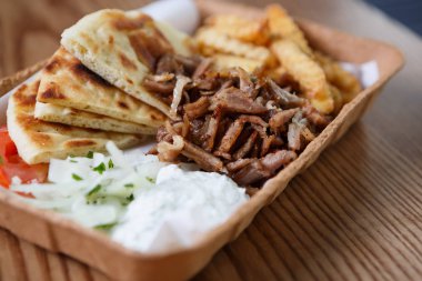 Kağıt tabak tablo büyük geleneksel Yunan mutfağı yemek hazır. Fast food medditeranean restoran menü yemekleri. Kavrulmuş et souvlaki yemeğin tadını çıkarın ve kızarmış gyros rulo. Abur cubur yemek listesi