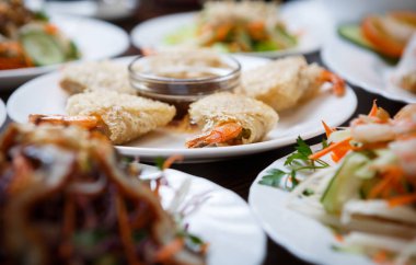 Egzotik Vietnam gıda restoran menü kapatın. Geleneksel Asya yemeği beyaz tabakta. Büyük yemek karides böreği, doğal diyet sebze salatası ile