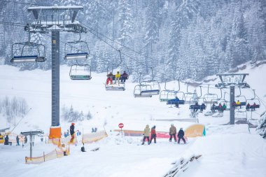 Bukovel, Ukrayna - 19 Mart, 2018: sandalye Asansör kayakçı ve Snowboard düşkünleri kış tatil için. Etkin turistler üzerinde snowboard binmek için Asansör ve kayaklar Bukovel Winter Park Karpat Dağları
