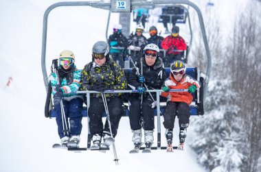 Bukovel, Ukrayna - 19 Mart, 2018: sandalye Asansör kayakçı ve Snowboard düşkünleri kış tatil için. Etkin turistler üzerinde snowboard binmek için Asansör ve kayaklar Bukovel Winter Park Karpat Dağları